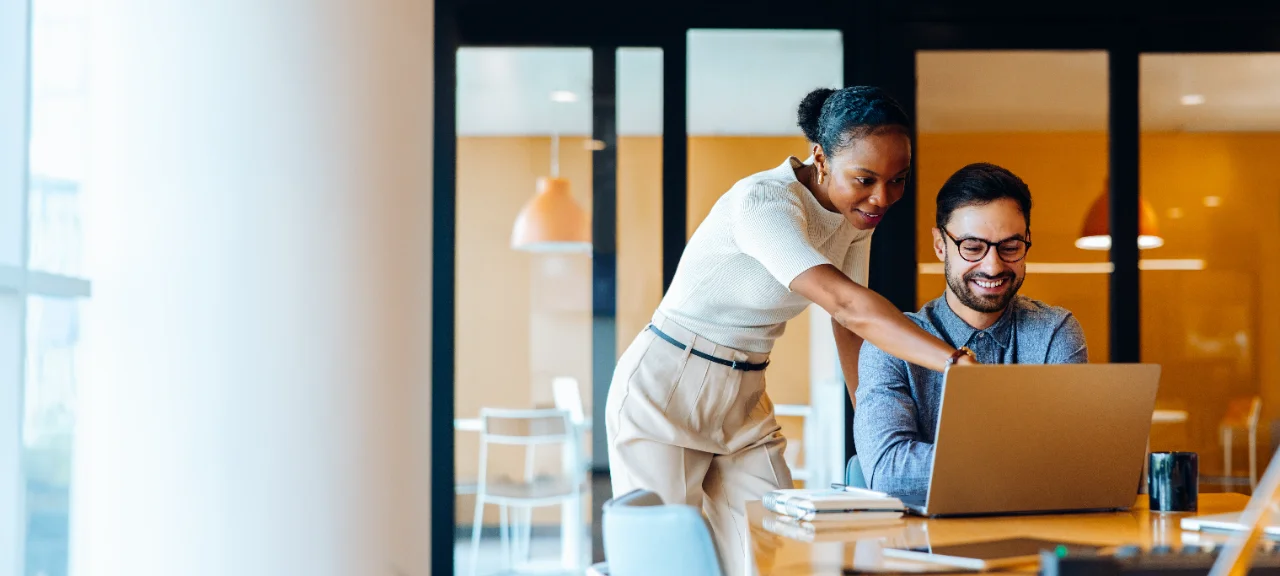 Des collègues célèbrent l'achèvement réussi d'une tâche ou d'un projet par un high-five dans un bureau.